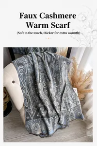 Dettaglio di sciarpa pashmina blu con motivo paisley e frange su un divano morbido