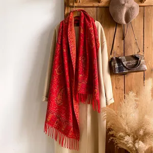 Vista dettagliata del motivo paisley rosso e delle frange su una sciarpa di lana retro