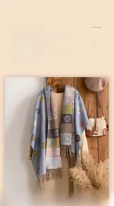 Detail of floral jacquard cashmere shawl with fringe hem and soft winter texture