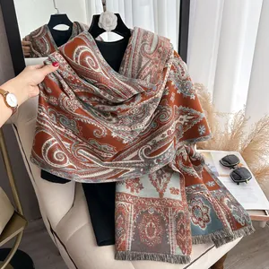 Détail d'un châle jacquard à motif paisley rouille avec franges et texture douce épaisse