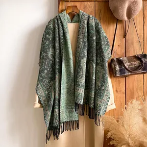 Dettaglio della sciarpa paisley verde con frange nere e trama jacquard floreale vintage