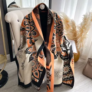 Detail of bohemian cashmere scarf with orange mandala print and soft fringe