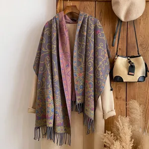 Detail of floral ethnic shawl with gold vine jacquard patterns and long fringes on coat