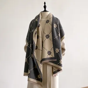 Détails d'une écharpe pashmina réversible à motif marguerites avec des franges