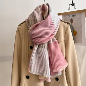 Detail of pleated color-block scarf in pink and grey styled on a khaki trench coat