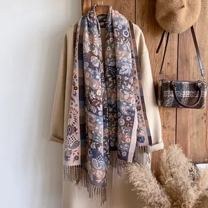 Détail du motif floral paisley ethnique et du plaid géométrique sur l'écharpe à franges