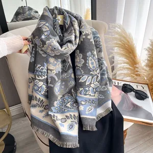 Close-up of paisley floral pattern on warm shawl with short fringe trim detail