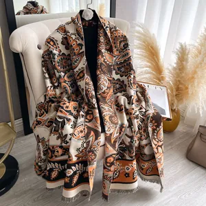 Detailed close-up of paisley pattern scarf with soft tassels on a minimalist armchair