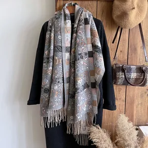 Détail de motifs paisley et floraux ethniques sur un châle d'hiver épais à franges