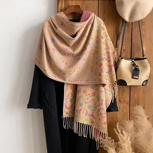 Floral ethnic style scarf with vintage patterns and tassels on a wooden hanger