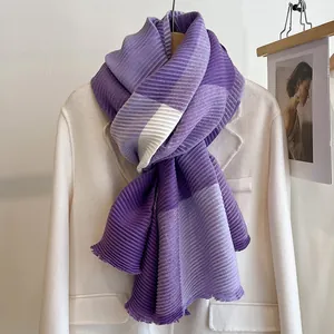 Detail of pleated scarf showing purple and white color-blocking texture on a coat