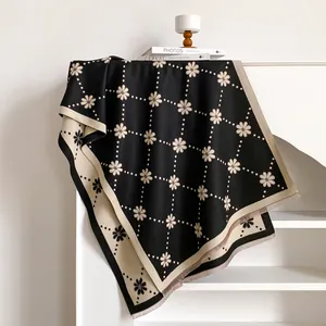 Détail du motif floral à pois et des franges d'une épaisse écharpe d'hiver en cachemire