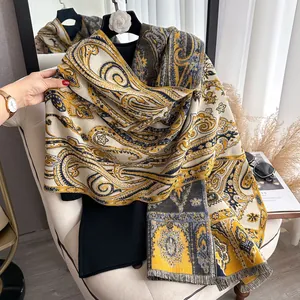 Gros plan d'un châle jacquard vintage à motif cachemire et franges dans les tons jaunes