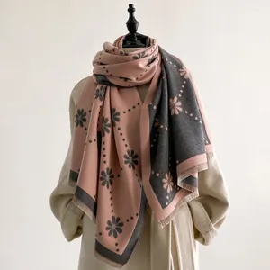 Vue détaillée du motif floral et des franges douces sur un châle réversible