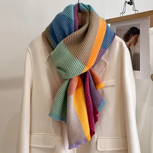 Detailed view of rainbow pleated scarf on white coat showing colorful vertical texture