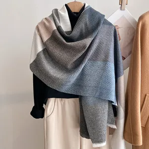 Detail of color-block striped knit scarf with ribbed texture in grey blue and beige