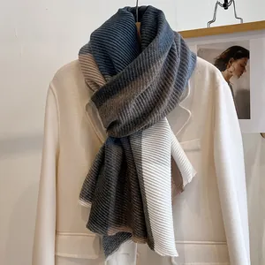 Detail of color-block knitted scarf with blue and brown stripes on a white blazer