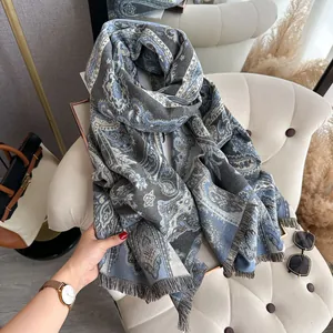 Vue détaillée du châle à motif cachemire bleu gris avec des franges décoratives