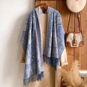 Sciarpa pashmina vintage blu navy con motivo paisley e frange su un cappotto invernale