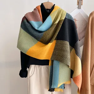 Detail of pleated knit shawl with geometric color blocks and accordion texture
