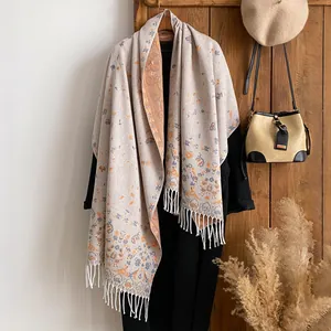 Ethnic floral cashmere scarf with orange paisley print and fringe on black coat