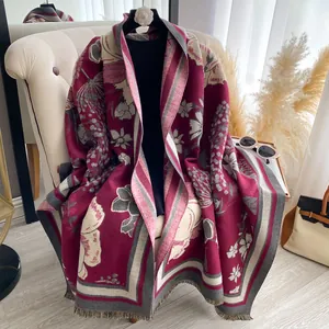 Close-up of elegant floral print cashmere scarf with fringe details in wine red