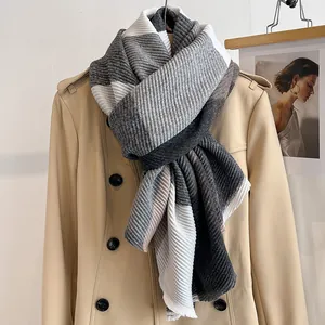 Detail of winter scarf featuring textured accordion pleats and grey plaid pattern
