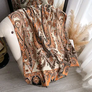 Châle vintage à motif cachemire avec franges drapé sur un fauteuil chic