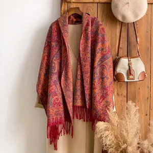 Détail du châle jacquard cachemire à motifs paisley rouges avec bordures à franges