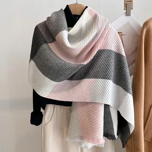 Detail of pleated patchwork scarf with pink, grey, and white color blocks on hanger