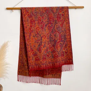 Détail du motif paisley rouge sur châle vintage avec franges décoratives