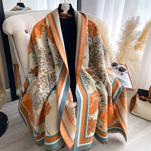 Detailed view of floral pattern and fine fringe on thick double-sided cashmere scarf