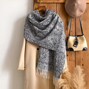 Détail du motif paisley sur un châle pashmina doux avec pompons sur un manteau en laine