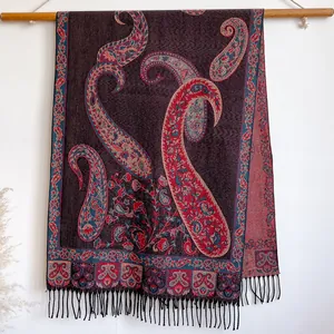 Detailed close-up of paisley jacquard pattern and black fringe on a thick shawl