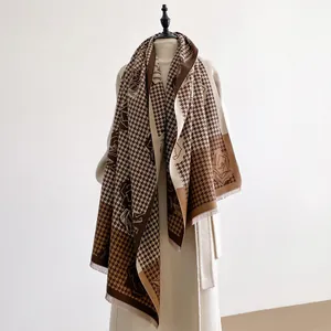 Dettaglio dello scialle in cashmere pied-de-poule con eleganti motivi floreali