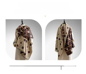 Detailed view of reversible cashmere scarf showing floral patterns and versatile styling