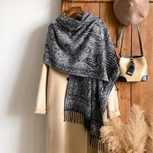 Détail d'une écharpe en cachemire rétro à motif cachemire et franges sur un manteau d'hiver