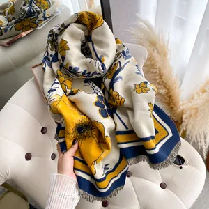 Detail view of thick winter scarf with yellow floral prints and fine fringe tassels