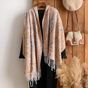 Détail du motif paisley vintage sur châle en cachemire avec élégantes franges blanches
