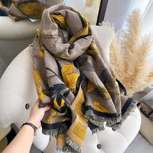 Detail of soft cashmere-like scarf with floral patterns and fine fringe edges