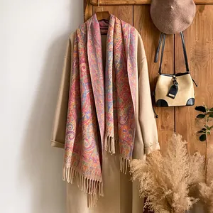 Détail d'une écharpe jacquard à motif cachemire avec franges sur un manteau