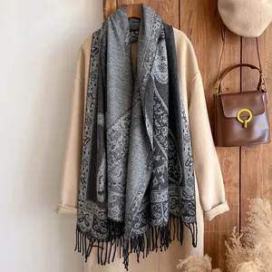 Close-up of vintage grey paisley pattern shawl with fringe on camel coat