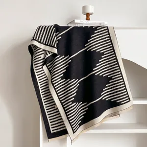 Close-up detail of soft knitted geometric pattern scarf with black and white texture