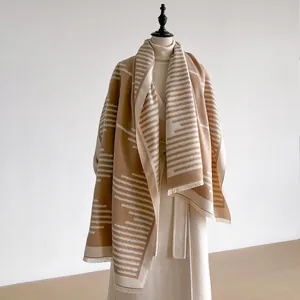 Detail of soft cashmere-like shawl featuring geometric stripes and fringe edges