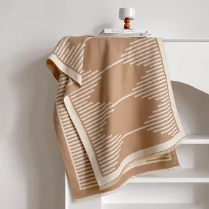Close-up of geometric pattern and soft tassel trim on a thick camel cashmere-feel shawl