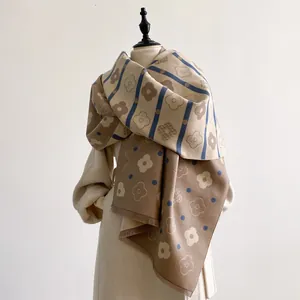 Beige and coffee reversible floral cashmere-like scarf with tassels on a mannequin