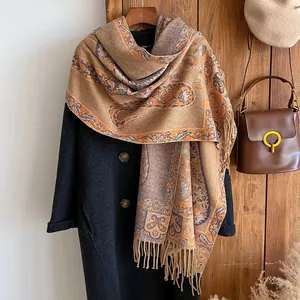 Orange paisley cashmere-feel pashmina shawl with tassel fringe on grey wool coat