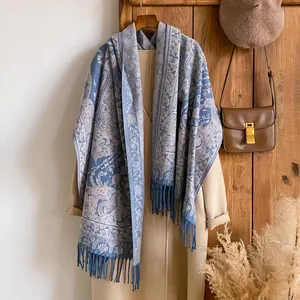 Écharpe jacquard paisley bleu et argent avec franges sur un manteau de style rétro