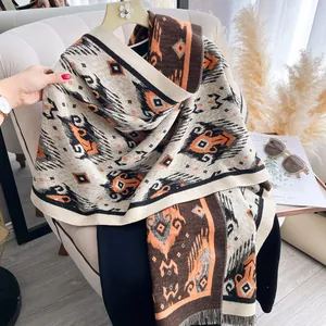Detailed close-up of thick winter shawl with bohemian geometric patterns and fine tassels