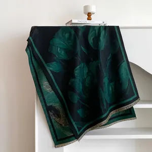 Detail of tulip pattern and tassel edges on a premium dark green cashmere-feel scarf